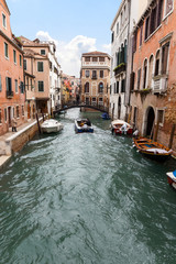 Fototapeta na wymiar The reflection of a colorful houses in water canal, Venice. Landmark of Veneto region. Italy
