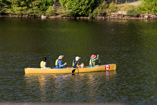 Four paddlers in a yellow canoe