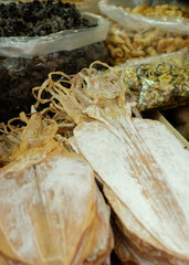 DRIED SQUID
Piles of dried squid display on the table with dried mushroom and nuts.