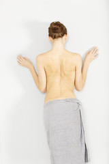 Topless woman leaning against wall