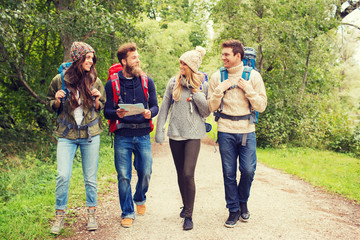 group of smiling friends with backpacks hiking