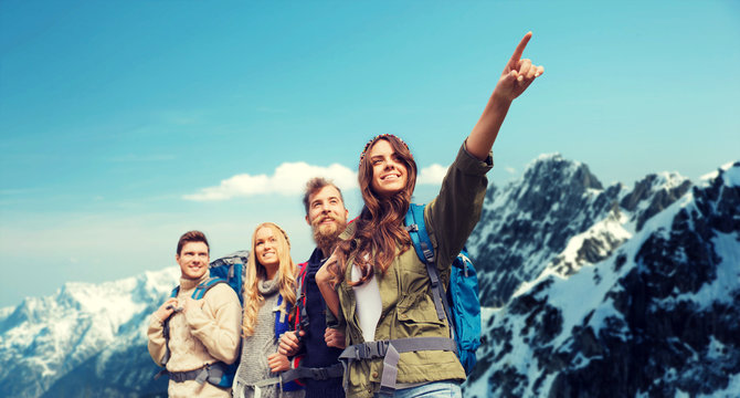 group of smiling friends with backpacks hiking