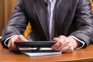 Businessman with tablet computer sitting at table