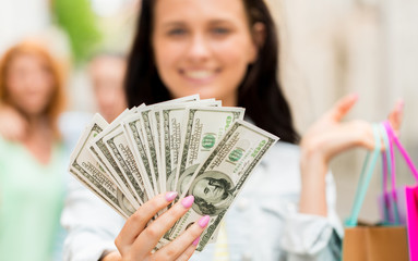 close up of woman with shopping bags and money