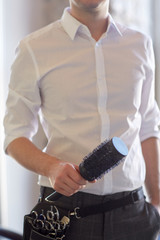 Naklejka premium close up of male stylist with brush at salon