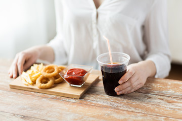 Obraz na płótnie Canvas close up of woman with snacks and cola