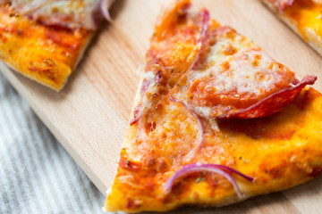 close up of homemade pizza slice on wooden table
