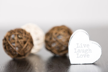 Three wicker balls with a white heart contain the text live laugh and love