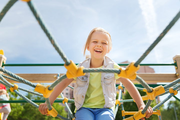 happy little girl climbing on children playground