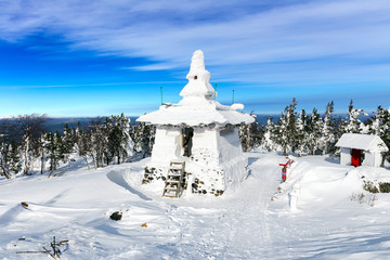 Buddhist stupa covered with snow on a mountain top