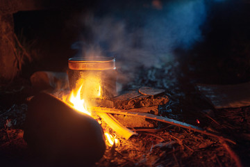 food is cooked in pot over a campfire at night