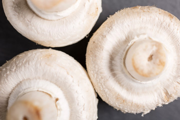 Fresh raw mushrooms on black slate