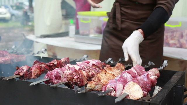 Chef prepares kebabs on the grill.