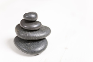Stacked pile of spa hot rocks on a light wooden surface
