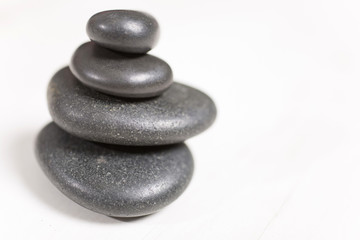 Stacked pile of spa hot rocks on a light wooden surface