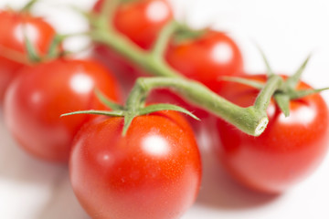 Beautiful fresh tomatoes on a light wooden surface