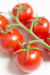 Beautiful fresh tomatoes on a light wooden surface