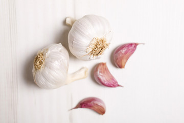 Fresh raw garlic on a light wooden kitchen work surface