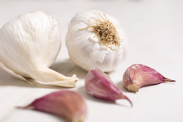 Fresh raw garlic on a light wooden kitchen work surface
