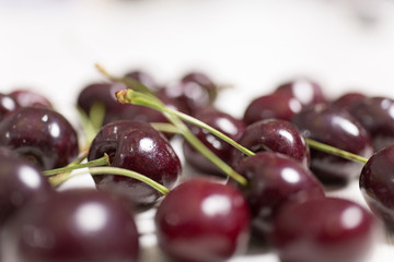 Fresh red cherries on a light wooden kitchen work surface