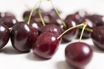 Fresh red cherries on a light wooden kitchen work surface
