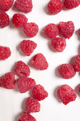 Fresh red raspberries on a light wooden kitchen surface