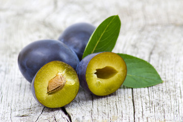 fresh plums on old wooden background