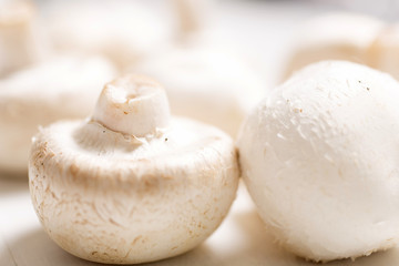 Fresh selection of chestnut mushrooms on a light wooden kitchen surface