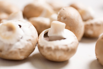 Fresh selection of chestnut mushrooms on a light wooden kitchen surface