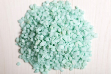 Detail of a pile of blue sand on a light wooden surface