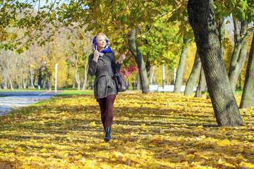 Fototapeta premium Young woman walking in autumn park