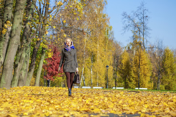 Young woman walking in autumn park