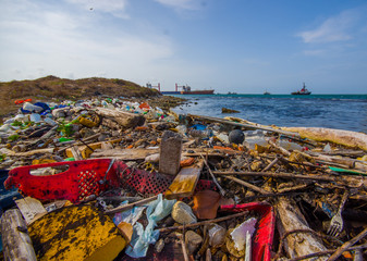 COLON, PANAMA - APRIL 15, 2015: Waste and pollution washing on the shores of the beach in city of Colon in Panama - obrazy, fototapety, plakaty