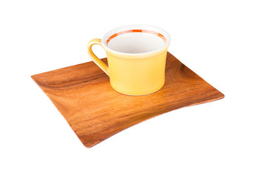 Yellow empty cup on a wooden plate isolated on white background