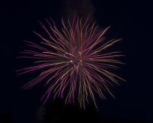 Purple and orange light trails from a fireworks long exposure. 