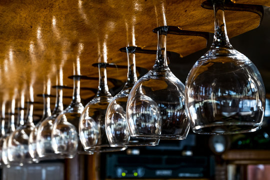 Wine glasses hang on the bar stock