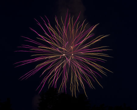 Purple and orange light trails from a fireworks long exposure. 