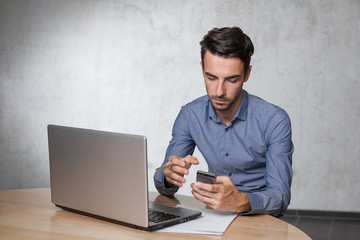 working young business man with laptop and smartphone