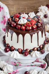 Cake decorated with chocolate, meringues and fresh berries
