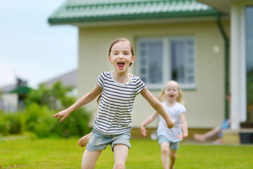 Obraz premium Two adorable little sisters having fun outdoors