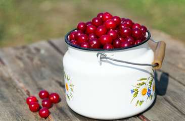 Ripe red cherry in a white bottle is a close-up