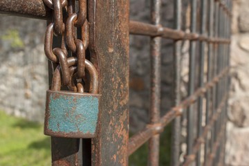 The lock on the chain. Old rusty chain with a lock on the iron gate. Symbol imprisonment and...