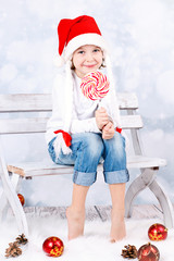 Obraz premium young girl in Santa's hat with christmas lollipop