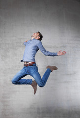 young man jumps in front of wall.