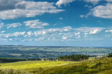 Fototapeta na wymiar Rural landscape with farm on top of far away hillside