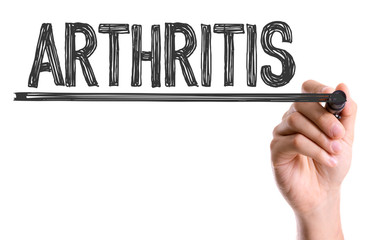 Hand with marker writing the word Arthritis