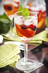 Glass of white sangria with fruits and berries