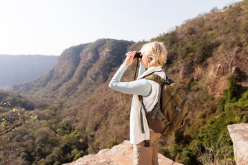 senior woman standing on top of the mountain