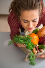 Woman with eyes closed smelling fresh fall vegetables