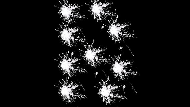 Capital letter B spelled with white sparklers on black background.